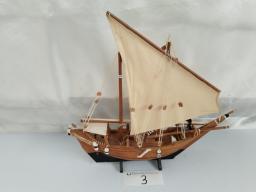 A crafted model of a traditional wooden sailing vessel